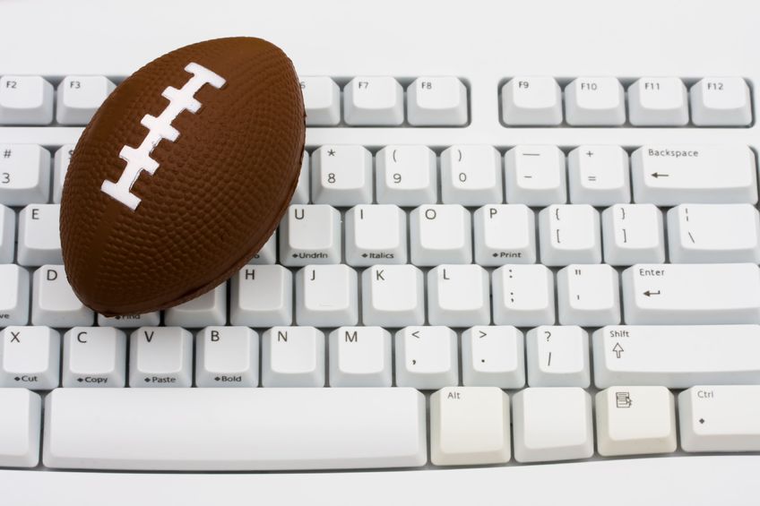 6517550 - a football sitting on a computer keyboard, playing fantasy football